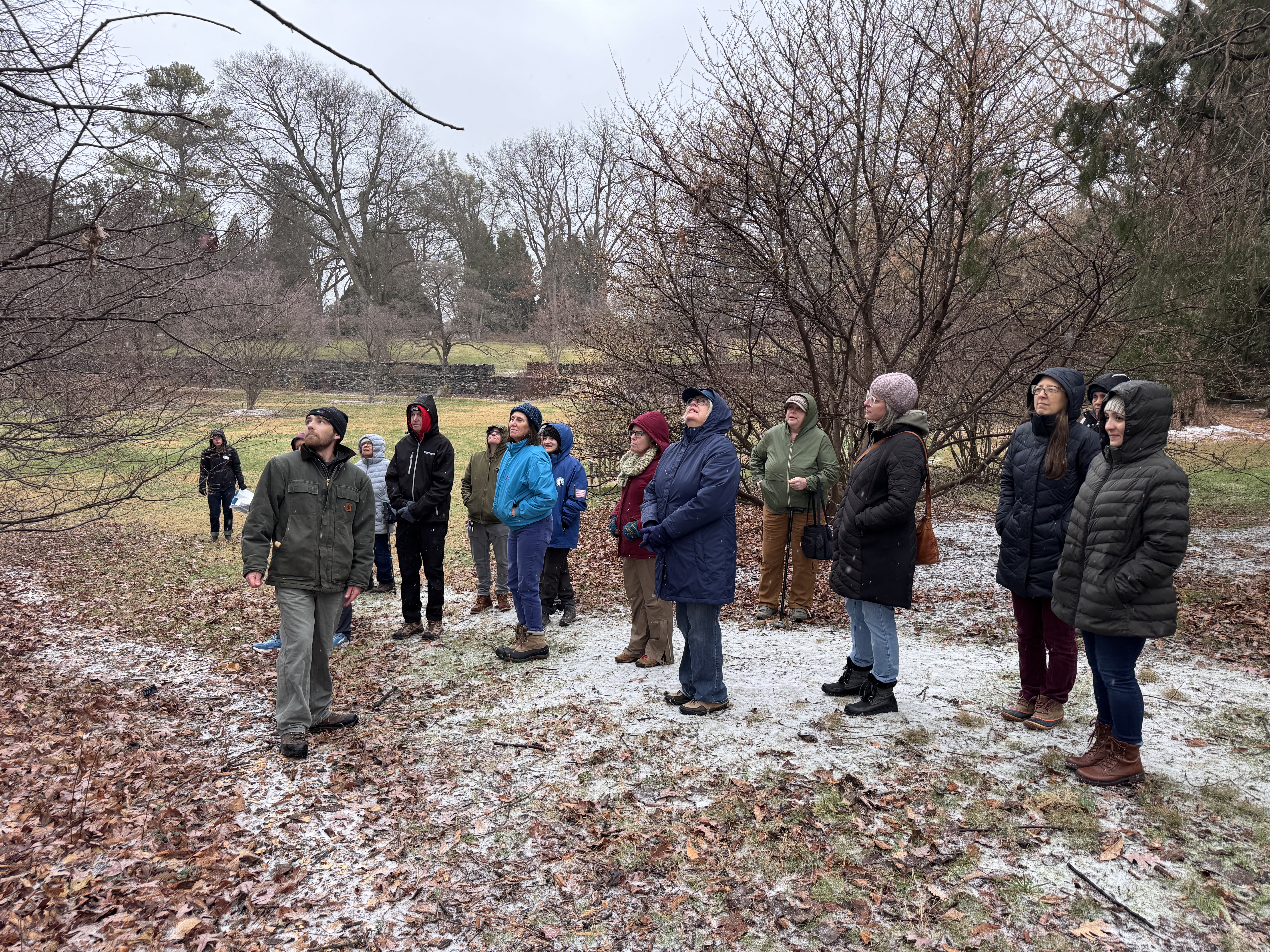 A group of public programs participants listening to an instructor on a wintery day with snow on the ground
